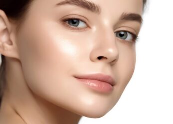 Close-up of a woman with smooth, clear skin looking over her shoulder against a light background