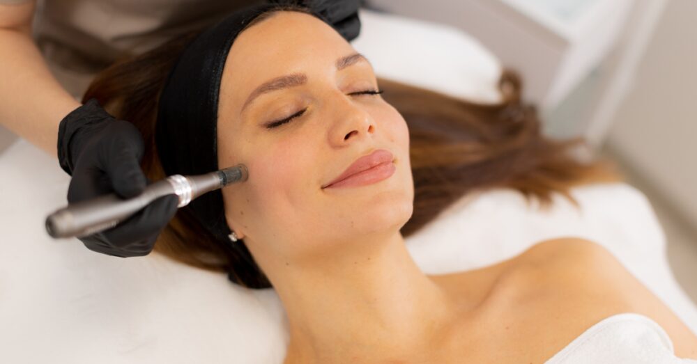 Woman lying back with her eyes closed during a professional microneedling session